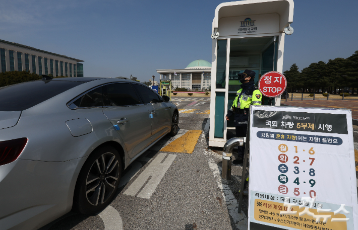 공공기관 차량 5부제 시행 첫 날인 25일 국회 정문에 관련 요일별 운휴차량 끝번호가 안내돼 있다. 황진환 기자