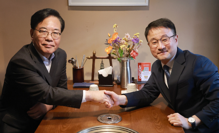 더불어민주당 한병도 원내대표와 국민의힘 송언석 원내대표가 30일 서울 영등포구청역 인근 식당에서 오찬 회동을 하며 악수하고 있다. 연합뉴스