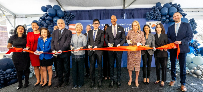 지난달 31일(현지 날짜) 미국 메릴랜드주 록빌 바이오의약품 생산 시설에서 열린 인수 완료식에서 참석자들이 기념 촬영을 하고 있다. 앞줄 왼쪽 다섯 번째부터 강경화 주미한국대사, 존 림 삼성바이오로직스 대표, 웨스 무어 메릴랜드 주지사, 에이프릴 델라니 미국 연방하원의원. 삼성바이오로직스 제공