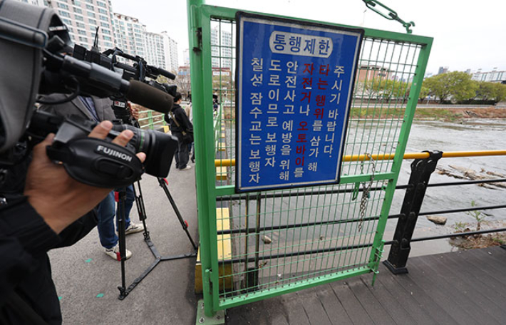지난달 31일 대구 북구 칠성동 잠수교 아래 신천에서 여성의 시신이 담긴 캐리어가 발견된 가운데 캐리어가 발견된 지점에서 취재진이 취재하고 있다. 연합뉴스