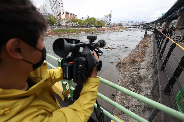지난달 31일 대구 북구 칠성동 잠수교 아래 신천에서 여성의 시신이 담긴 캐리어가 발견된 가운데 캐리어가 발견된 지점에서 취재진이 취재하고 있다. 연합뉴스