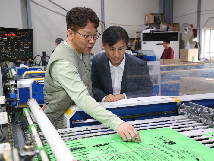백호성 조달청 구매사업국장(오른쪽)이 충남  금산군에 있는 종량제봉투 생산기업인 경승산업을 방문해 생산시설을 둘러보고 있다. 조달청 제공