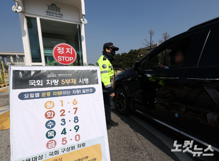 공공기관 차량 5부제 시행 첫 날인 25일 국회 정문에 관련 요일별 운휴차량 끝번호가 안내돼 있다. 황진환 기자