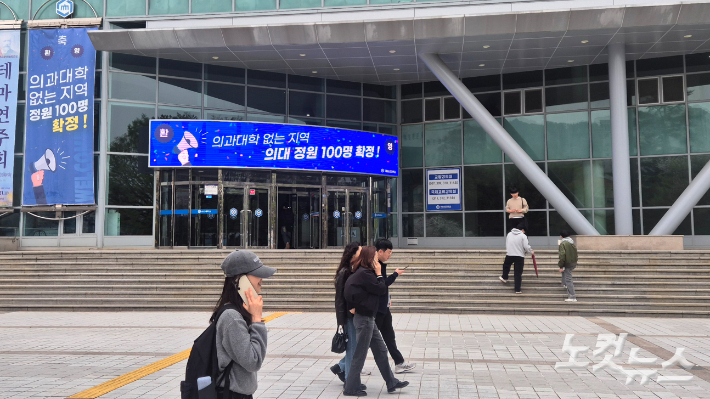 지난 1일 오전 전남 순천시 순천대학교 캠퍼스 위를 학생들이 걸어가고 있다. 학생들 옆으로는 '의과대학 없는 지역 의대 정원 100명 확정'이라는 홍보문구가 적혀 있다. 한아름 기자