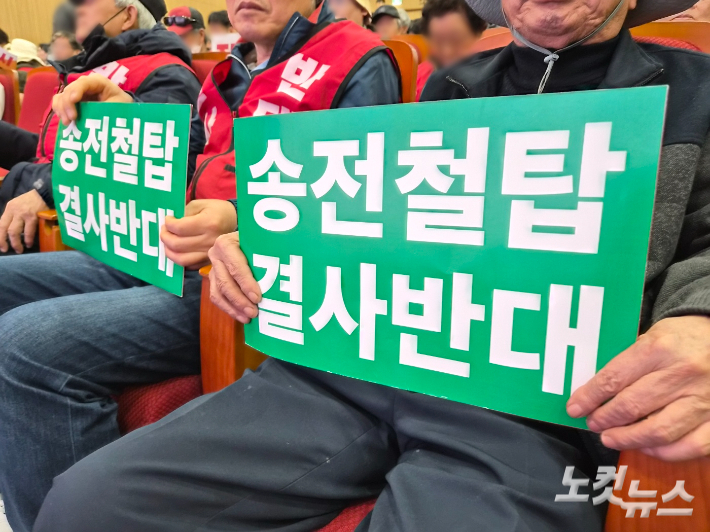 최근 충남에서 열린 토론회에 참석한 주민들의 손에 '송전철탑 결사반대'라고 적힌 팻말이 들려 있다. 김정남 기자