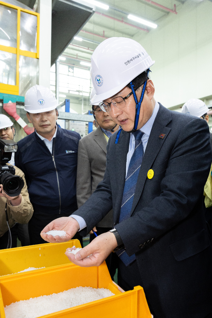 김성환 기후에너지환경부 장관이 3일 인천 서구 소재  '구립 장애인 직업재활시설'을 찾아 종량제봉투 생산 현장을 점검하며, 재생원료를 살펴보고 있다. 기후부 제공