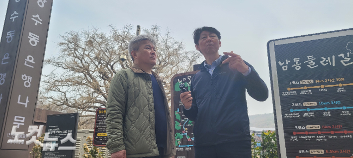 이 의원이 장수동은행나무 앞에서 오억환 씨와 대화를 나누고 있다. 박창주 기자