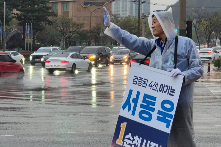 서동욱 순천시장 예비후보가 빗속에 우의를 입고 시민들에게 손을 흔들고 있다. 서동욱 예비후보 제공