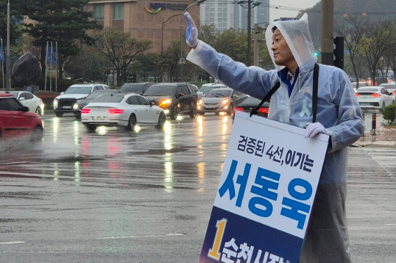 서동욱 순천시장 예비후보가 빗속에 우의를 입고 시민들에게 손을 흔들고 있다. 서동욱 예비후보 제공