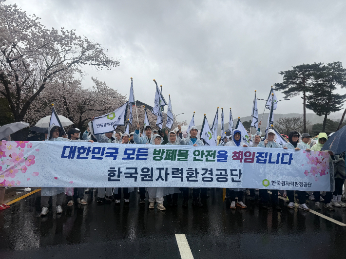 한국원자력환경공단 임직원들이 마라톤 출발 전에 현수막을 들고 행진하고 있다. 공단 제공
