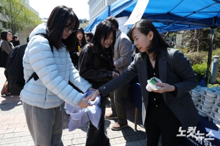 중동사태로 비닐 원료 수급 부족이 이어지고 있는 가운데 7일 서울 용산구 숙명여자대학교에서 학교 교무위원들이 중간고사를 앞둔 학생들에게 일회용 비닐봉투 없이 간식을 배부하고 있다.