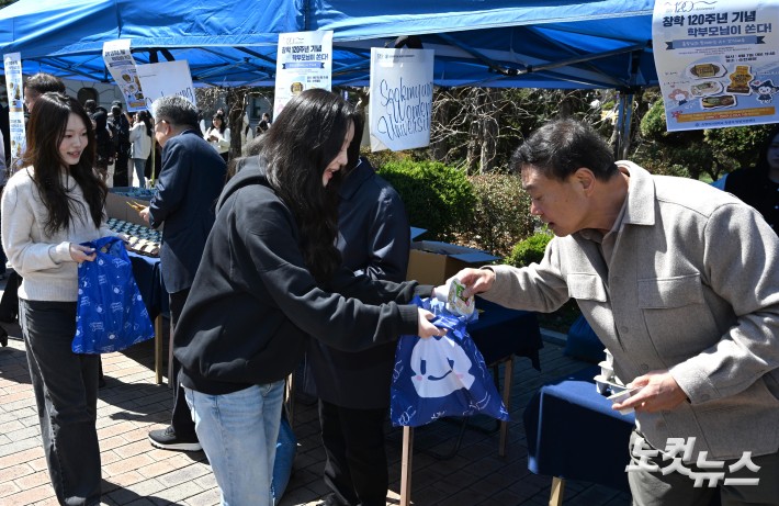중동사태로 비닐 원료 수급 부족이 이어지고 있는 가운데 7일 서울 용산구 숙명여자대학교에서 학교 교무위원들이 중간고사를 앞둔 학생들에게 일회용 비닐봉투 없이 간식을 배부하고 있다.