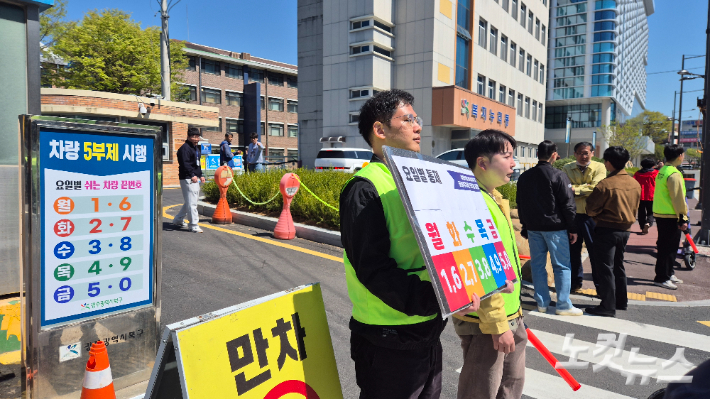 8일 오전 11시쯤 광주광역시 북구청 공영주차장 입구에서 구청 관계자들이 공영주차장 이용 차량 대상 5부제 의무화 내용을 안내하고 있다. 한아름 기자