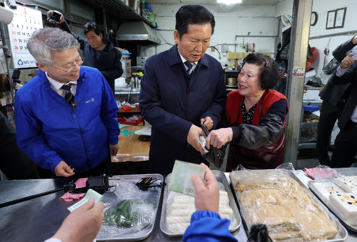 더불어민주당 정청래(가운데) 대표가 여수시 서시장의 한 떡집에서 상인과 이야기를 나누고 있다. 연합뉴스