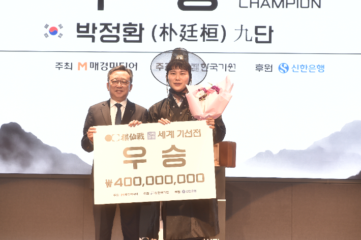 '세계기선전' 우승보드를 든 박정환 9단(사진 오른쪽)과 시상자 신한은행 정상혁 은행장. 한국기원 제공
