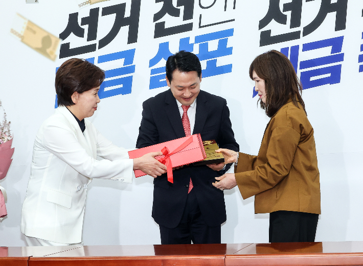 국민의힘 장동혁 대표와 양향자 최고위원이 9일 국회에서 열린 '100만 책임당원 돌파 기념식'에서 안현주 씨에게 특별 제작한 100만 책임 당원증과 기념 선물을 수여하고 있다. 연합뉴스