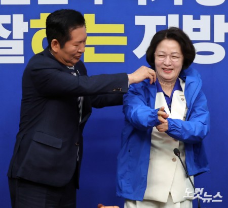 더불어민주당 정청래 대표가 13일 서울 여의도 국회에서 열린 경기도지사 후보 환영식에서 추미애 후보에게 당 점퍼를 입혀주고 있다.