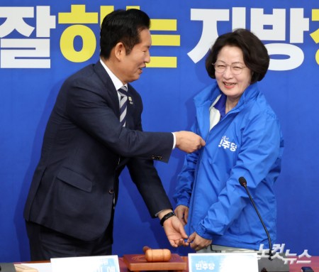 더불어민주당 정청래 대표가 13일 서울 여의도 국회에서 열린 경기도지사 후보 환영식에서 추미애 후보에게 당 점퍼를 입혀주고 있다.