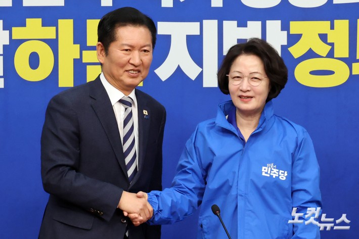 더불어민주당 정청래 대표가 13일 서울 여의도 국회에서 열린 경기도지사 후보 환영식에서 추미애 후보에게 당 점퍼를 전달하고 악수를 하고 있다.