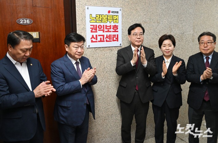 송언석 국민의힘 원내대표 및 참석자들이 13일 오전 서울 여의도 국회에서 열린 노란봉투법 권익보호신고센터 현판식에서 현판 제막을 마친 뒤 박수를 치고 있다. /2026.04.13