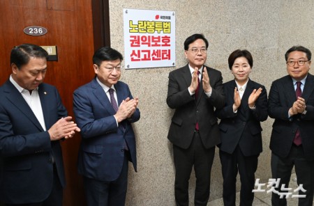 송언석 국민의힘 원내대표 및 참석자들이 13일 오전 서울 여의도 국회에서 열린 노란봉투법 권익보호신고센터 현판식에서 현판 제막을 마친 뒤 박수를 치고 있다. /2026.04.13