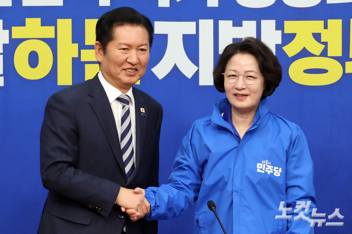 더불어민주당 정청래 대표가 13일 서울 여의도 국회에서 열린 경기지사 후보 환영식에서 추미애 후보에게 당 점퍼를 전달하고 악수를 하고 있다. 윤창원 기자