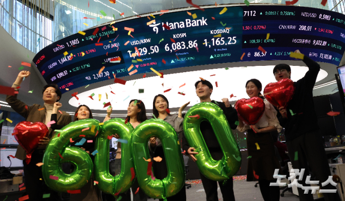 코스피가 종가 기준 사상 처음 6천선을 돌파했던 지난 2월 25일 오후 서울 중구 하나은행 본점 딜링룸에서 직원들이 축하 세리머니를 하고 있다. 박종민 기자