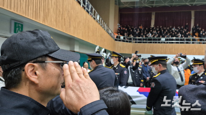 14일 오전 두 순직 소방관에 대한 영결식이 끝난 후 밖으로 나가는 운구 행렬에 동료 소방관이 경례하고 있다. 한아름 기자