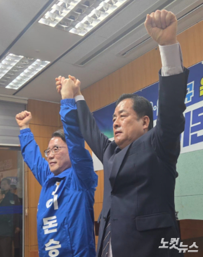 민주당 완주군수 후보 본경선에 나섰던 이돈승, 서남용 예비후보가 15일 전북도의회 기자회견에서 손을 맞잡아 들고 있다. 최명국 기자