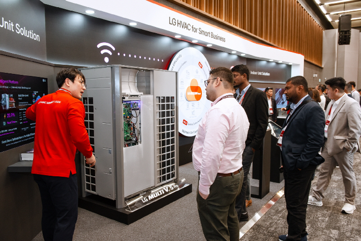 LG전자 직원이 고효율 인버터 컴프레서가 적용된 LG전자의 멀티 V 5 프로(MULTI V 5 Pro)와 데이터 기반 통합 제어 솔루션 '비컨(BECON)'을 소개하고 있다. LG전자 제공