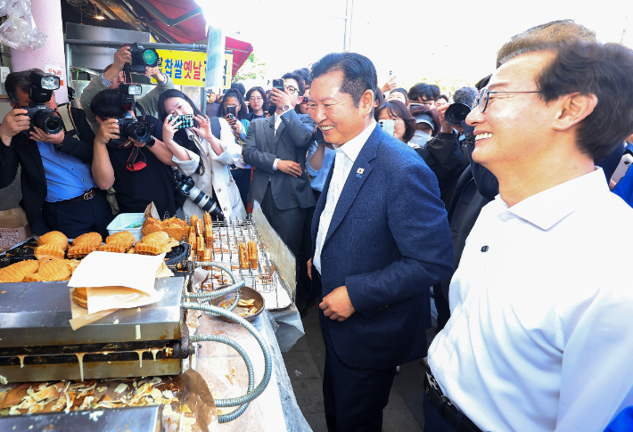더불어민주당 정청래 대표와 전재수 부산시장 후보가 15일 오후 부산 부산진구 부전시장을 돌며 상인들에게 인사하고 있다. 연합뉴스