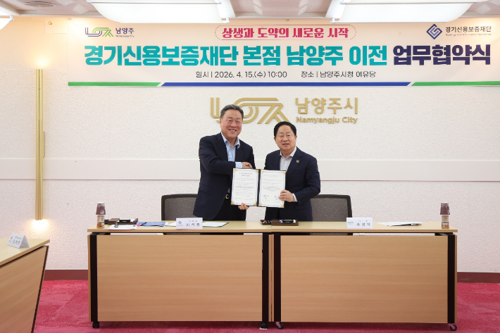 시석중 경기신용보증재단 이사장(왼쪽)과 주광덕 남양주시장이 15일 남양주시청에서 '경기신용보증재단 본점 남양주 이전 업무협약'을 맺은 뒤 기념사진을 찍는 모습. 경기신용보증재단 제공