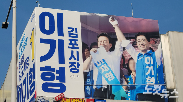 김포시 운양역사거리에 위치한 이기형 예비후보 선거사무실 외벽에 붙은 현수막 모습. 이재명 대통령과 이 예비후보가 함께하고 있다. 박창주 기자