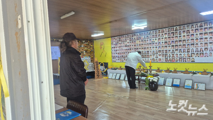 16일 오전 전남 진도군 진도항을 찾은 진도군민 박상근 씨가 팽목 기억관에서 희생자들의 사진을 바라보고 있다. 한아름 기자