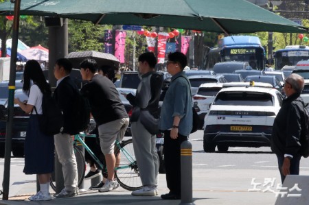 그늘막에서 신호 기다리는 시민들