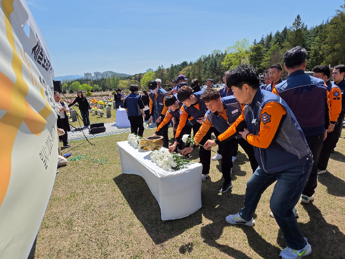 소방대원들이 세월호 참사 헬기 수색 지원을 마치고 복귀하다, 헬기 추락으로 순직한 소방관 5명에게 헌화하고 있다. 박우경 기자