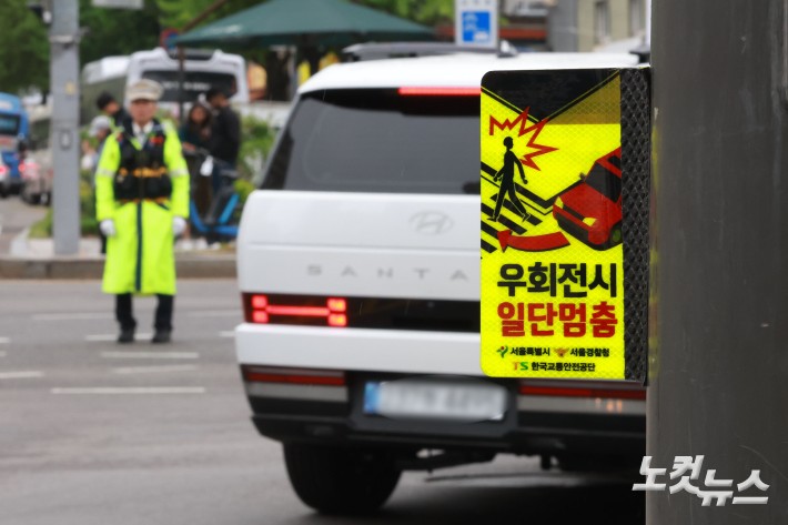 경찰이 우회전 일시 정지 의무 위반 차량에 대해 두 달간 집중 단속에 나서는 가운데 20일 서울 종로구 세종대로에서 경찰이 교통 정리를 하고 있다.경찰청은 지난 2023년 도입된 우회전 일시정지 제도를 현장에 안착시켜 우회전 사고에 취약한 보행자 안전을 확보하기 위해 이날부터 오는 6월 19일까지 2개월간 우회전 통행방법 위반에 대해 집중단속을 실시한다고 밝혔다.