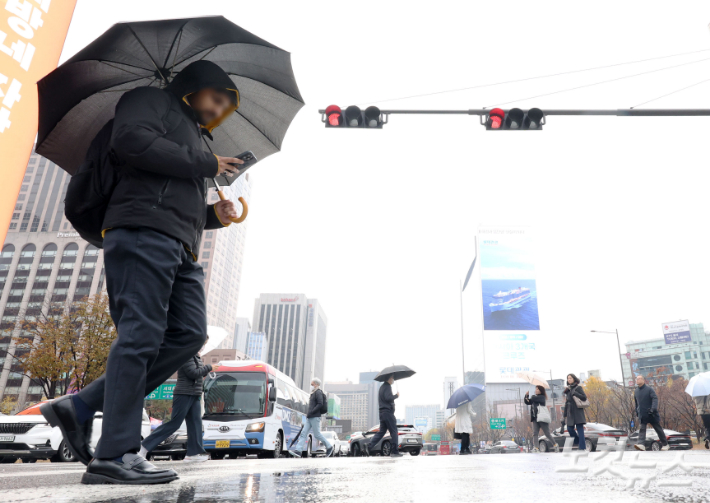 서울 종로구 광화문네거리에서 우산을 쓴 시민들이 발걸음을 재촉하고 있다. 류영주 기자