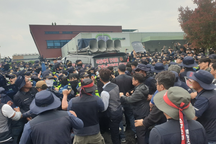 지난 20일 경남 진주 CU물류센터 앞에서 원청 교섭을 요구하는 화물연대 조합원들과 경찰 측이 대치하고 있다. 연합뉴스