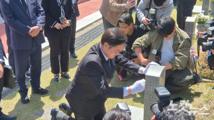 우 의장이 윤상원 열사의 묘소를 찾아 무릎을 꿇고 윤 열사의 비석을 닦고 있다. 한아름 기자