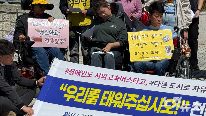 전남 지역 장애인들이 21일 오후 광주지방법원 앞에서 열린 기자회견에서 버스 이동권 보장을 요구하는 손팻말을 들고 있다. 김한영 기자
