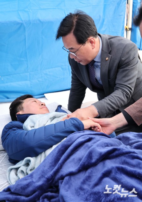 송언석 국민의힘 원내대표가 22일 서울 여의도 본관 앞에서 단식 농성 중인 안호영 더불어민주당 의원을 방문해 대화하고 있다.