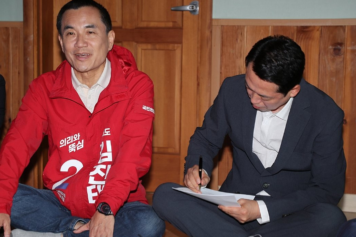 국민의힘 김진태 강원도지사 후보의 발언을 메모하고 있는 장동혁 당대표. 연합뉴스