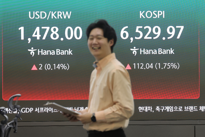 코스피가 장중 6500을 돌파한 23일 서울 중구 하나은행 딜링룸에서 직원들이 업무를 보고 있다. 연합뉴스