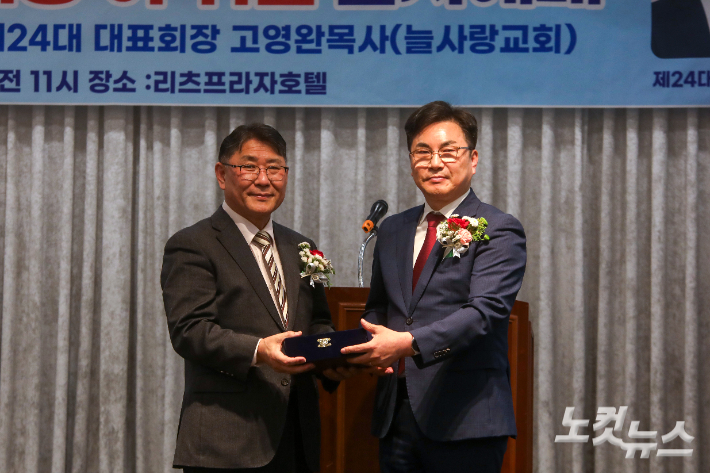 이임하는 직전 대표회장 추이엽 목사(왼쪽)에게 신임 대표회장 고영완 목사가 공로패를 전달하고 있다. 최화랑 기자