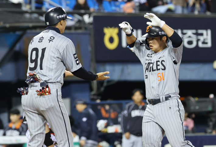 23일 서울 잠실야구장에서 열린 프로야구 한화-LG경기. 5회초 투아웃 한화 문현빈이 솔로포를 날린 뒤 추승우 코치와 하이파이브를 하고 있다. 연합뉴스 