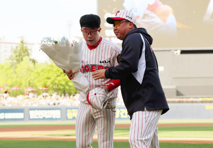 25일 광주기아챔피언스필드에서 열린 프로야구 롯데 자이언츠와 KIA 타이거즈의 경기. KBO 최초로 2200탈삼진을 달성한 KIA 양현종(사진 왼쪽)이 이범호 감독으로부터 꽃다발을 받고 있다. 연합뉴스