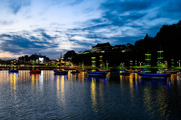 지난 24일 '2026 밀양국가유산야행' 현장에서 영남루의 야경과 밀양강 위를 수놓은 어화 돛단배가 어우러져 장관을 연출하고 있다. 밀양시 제공