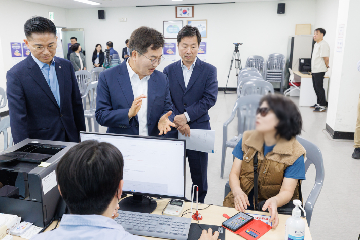 김동연 경기지사(왼쪽 세번째)는 27일 안양시 관양동 행정복지센터를 찾아 '고유가 피해지원금' 접수 상황을 직접 점검했다. 사진은 김 지사가 접수를 받기 위해 방문한 도민과 대화하는 모습. 경기도 제공
