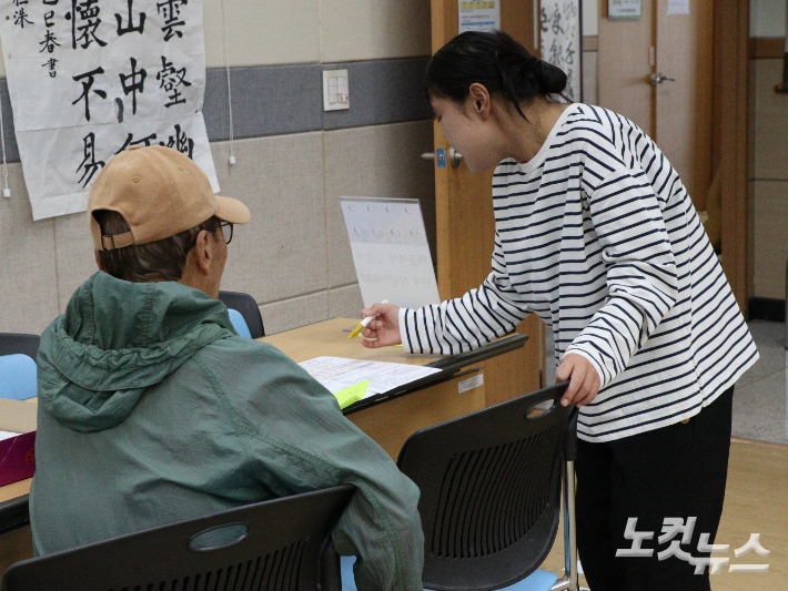 내덕2동 행정복지센터에 방문한 한 어르신이 직원으로부터 피해지원금 설명을 듣고 있다. 임성민 기자